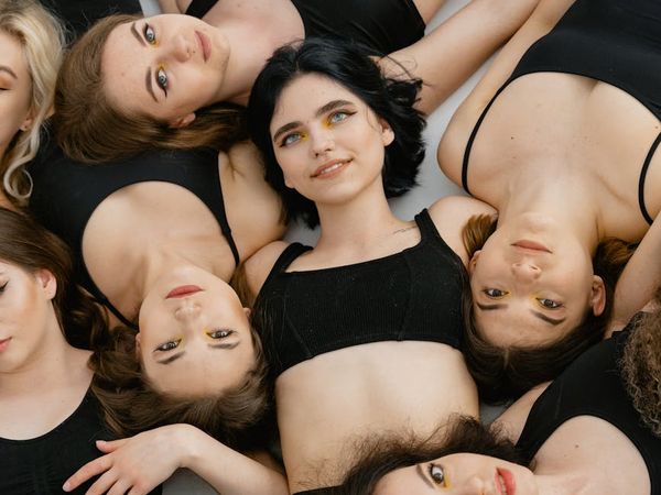 Group of diverse people smiling in a bright yoga studio.