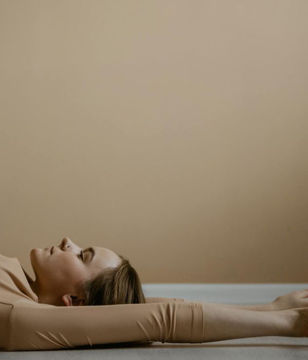Woman in a calm yoga pose on a serene background.